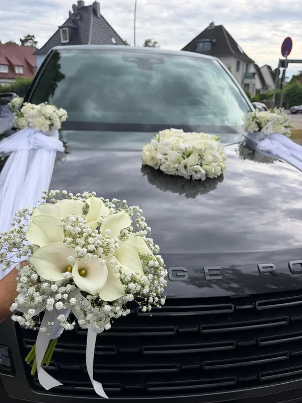 Schwarzer Brautwagen mit weißer Calla-Haube und Rosenschmuck