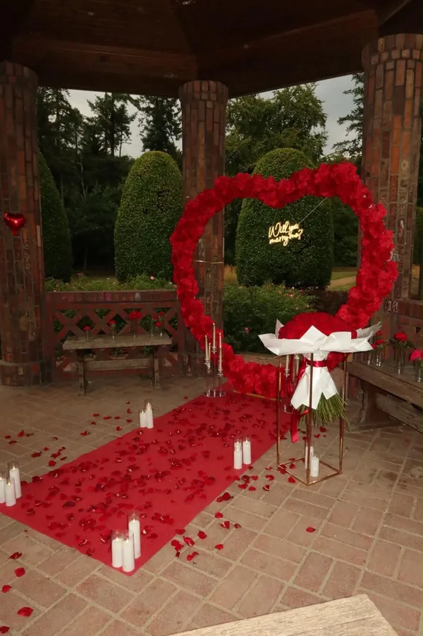 Heiratsantrag-Deko: Herzbogen mit Schriftzug „Will you marry me?“ im Pavillon