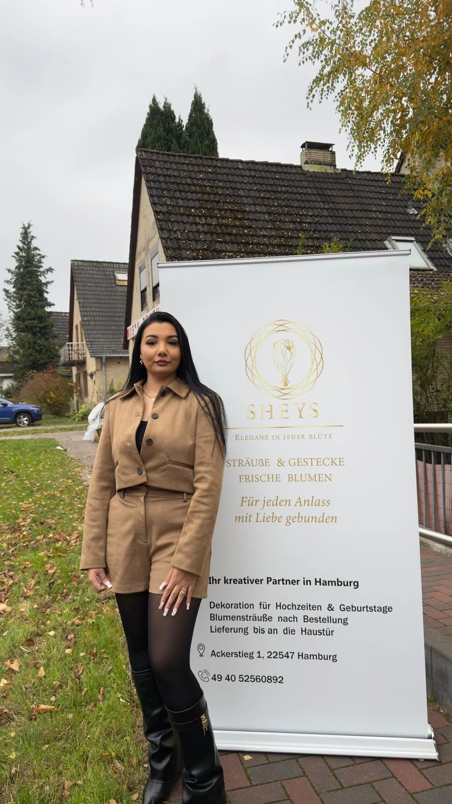 Shayenne Beci, Inhaberin von Sheys Flowers, neben dem Werbebanner